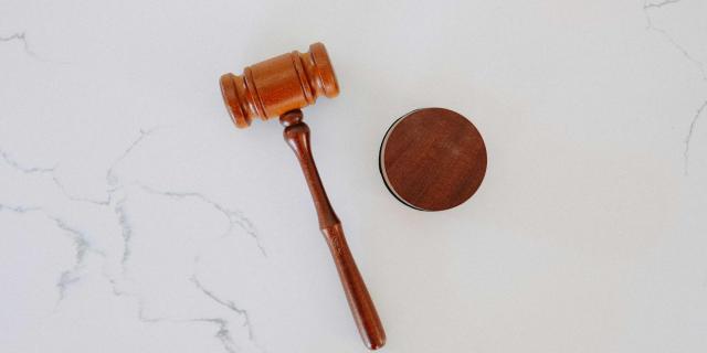 on a marble background, you can see a hammer which is used in auctions right in the middle