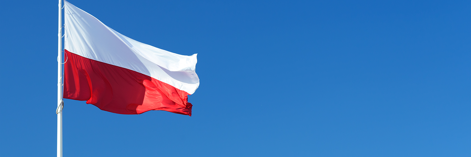 In the background the blue sky. In the front on the left, the polish flag on a mast