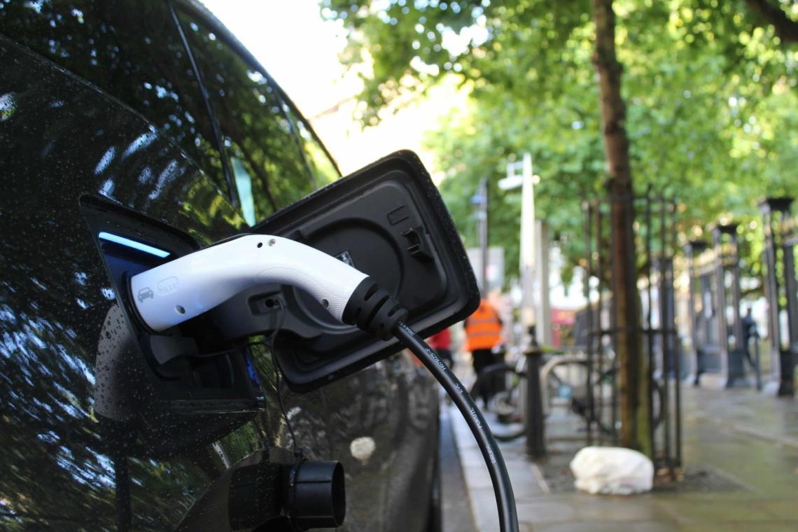 Electric car charging A close up photo of the charging port of an electric car. The charging cable is plugged in