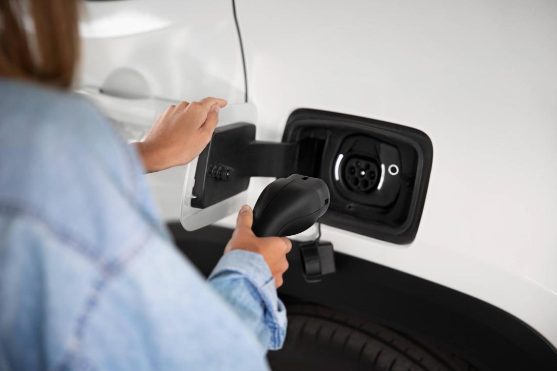 EV charge close up A close up view of a person going to charge an electric vehicle