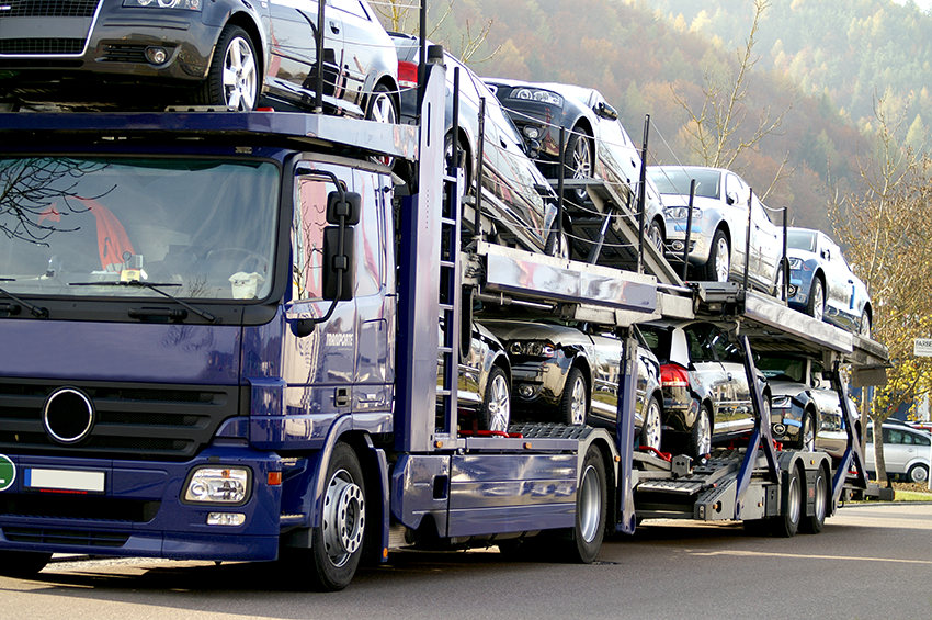 Truck transporting vehicles a tdark blue ruck transporting cars viewed from the front
