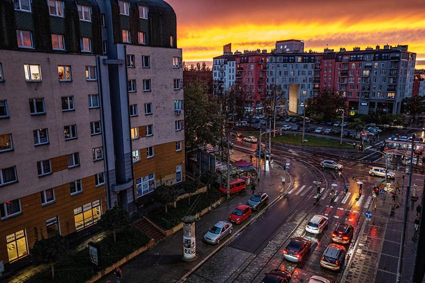 The view from a building of a crossing the a polish city in the evening with the sunset behind the buildings