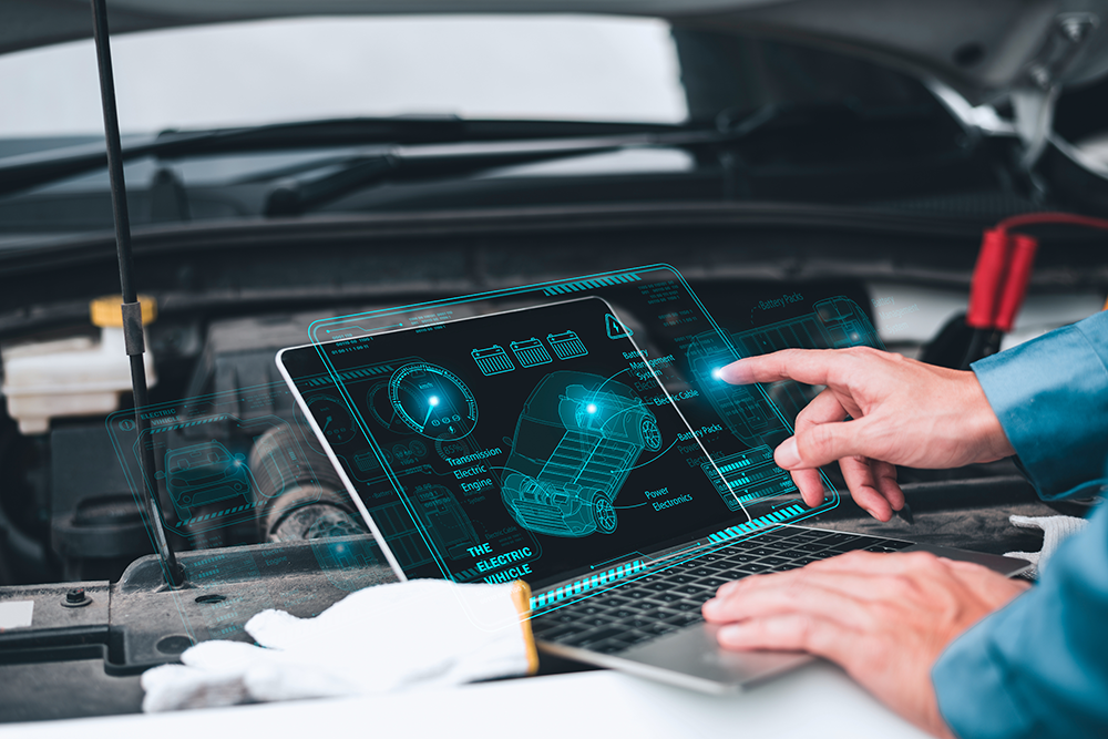 vehicle control with computer A man on a portable computer which is on the open hood of a car in front of the motor. We only see the hands of the man, he is pointing at the screen. On the screen, we can see in transparency a car and its technical details